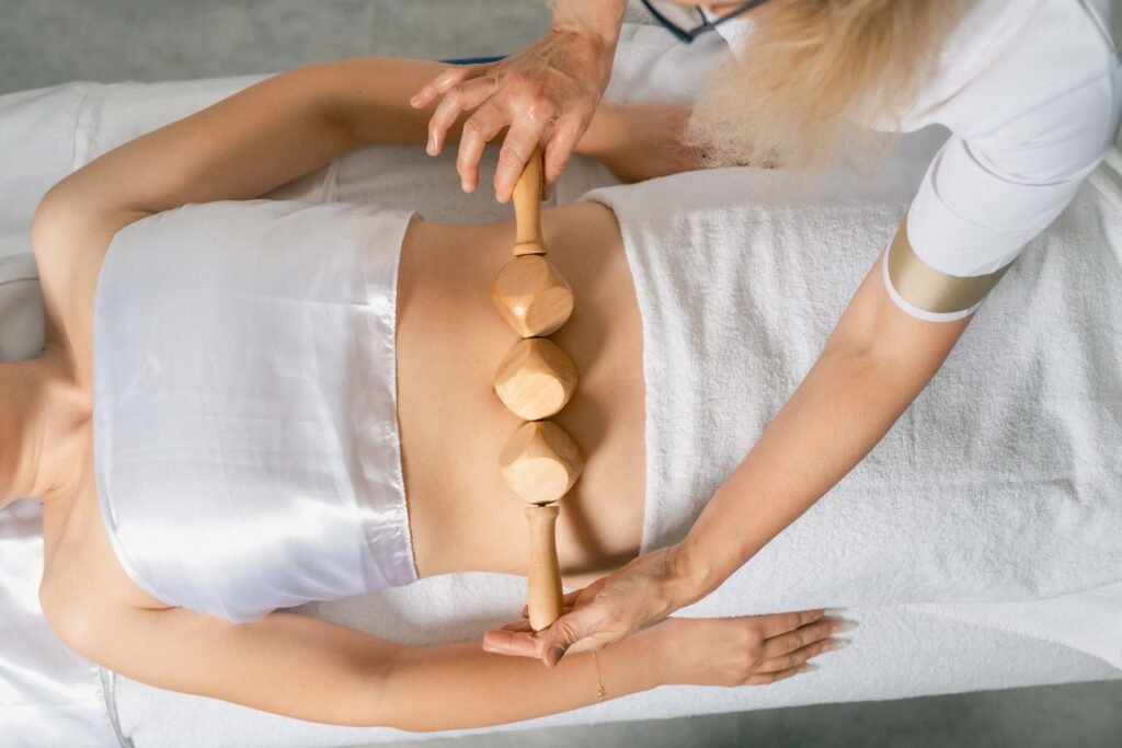 Massage de madérothérapie réalisé avec des outils en bois pour le remodelage du corps à Rueil-Malmaison.