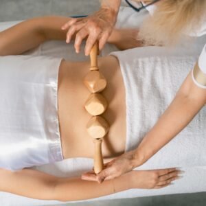 Massage de madérothérapie réalisé avec des outils en bois pour le remodelage du corps à Rueil-Malmaison.